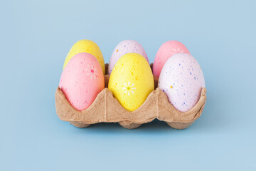 Eco basket with colorful easter eggs on pastel light blue background. minimalistic decoration, minimal composition. Front view, place for text, banner
