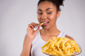 African American girl eating fries isolated.