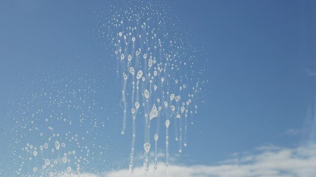 The housewife washes the window thoroughly with a scrubber, removing the soapy water and leaving the glass crystal clear. Cleaning and hygiene.