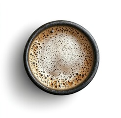 Overhead view of a dark-colored coffee cup with frothy crema, isolated on white