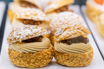 A cream puff is a classic pastry made from light and airy choux dough, baked to a golden brown perfection. The delicate, hollow shell is filled with a luscious, smooth cream—often custard