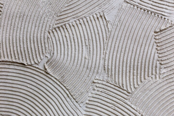 Abstract plaster texture closeup with decorative lines. Plaster curved lines create artistic abstract pattern. Concept of modern plaster textured surface for stylish interior and creative decor