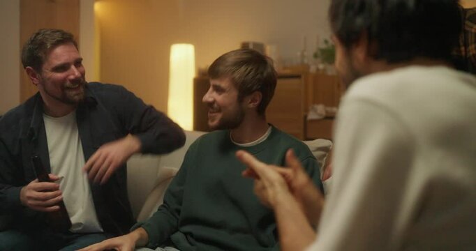 Happy Cheerful guy ringleader having fun with his friends Sitting on the sofa during a bachelor party at home in the evening