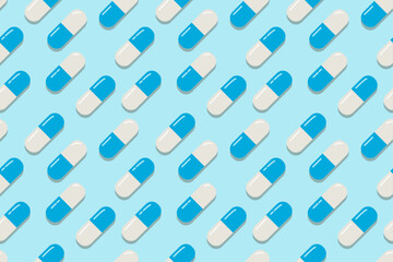 Blue medical capsules seamless pattern. Pills blue background. Capsules pattern in blue and white. A blue medical illustration. A diagonal seamless pattern with medical pills.