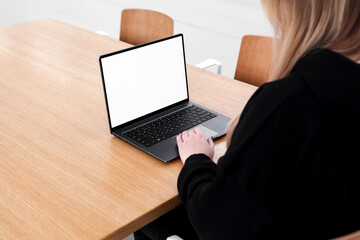 Young white woman working on computer with blank copy space screen on table in home office. close up female businesswoman hands typing text, surfing internet on modern laptop. mock up, front view