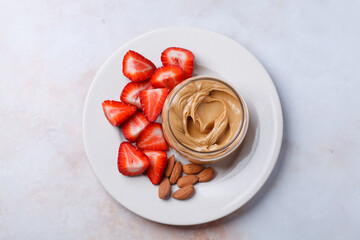 Almond homemade nut butter with strawberry. Vegan snack concept.