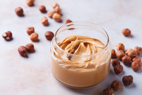 Hazelnut homemade nut butter in glass jar. Vegan snack concept.