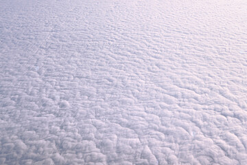 A white background is a cloud or a blanket of snow in the sky spread over the entire horizon. Airplane view of the sky, beautiful background.