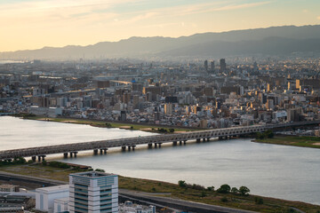 View of the city along the banks of the Yodo River from the observation deck on the roof of the Umeda Sky Building skyscraper on a sunny evening, Osaka, Japan