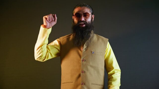 Bearded politician in ethnic attire speaks at rally