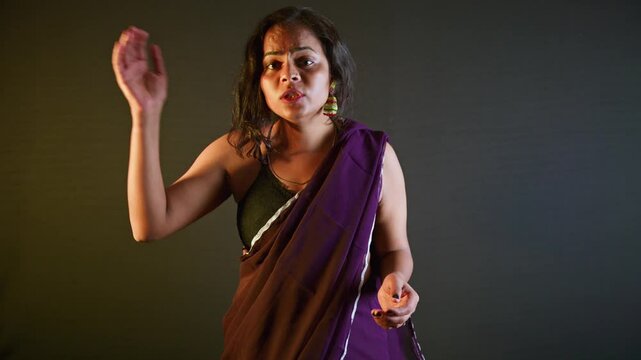 Woman wearing traditional attire talks earnestly inside