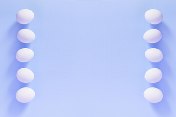 Frame of Easter white natural eggs set isolated on pastel blue background. Stylish trendy composition with chicken egg. Flat lay, top view, place for text. Happy eco-friendly holiday, minimal concept