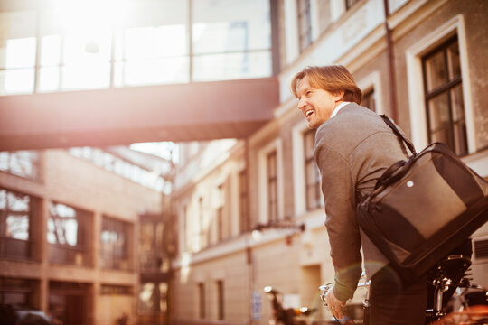 Mature man cycling in the city while commuting to work