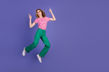 Young stylish woman with vibrant outfit posing confidently against a purple background showing an...