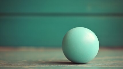 Single teal egg on rustic wood.