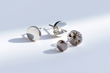 Elegant Silver Stud Earrings with Reflective Surface on Soft Background