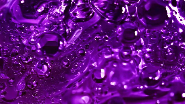 An eruption of deep violet berry juice droplets rushing toward the camera in slow motion, glossy and slightly sticky with a rich, organic texture, reflecting subtle purple hues under studio lighting