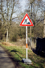 Warning road sign about repair work. The road sign is installed on a pole with a warning about road...