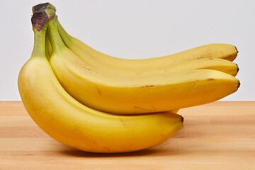 A bunch of ripe bananas lies on a wooden surface