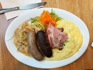 A typical German specialty: a meat platter, schlachtplatte, with liver sausage, crackling, sauerkraut, belly and mashed potatoes.