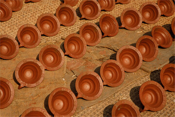 A background of small, round claypots drying in th sunshine on a carpet