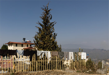 Washing thrown over a fence to dry in a Himalayan village