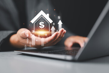 Real Estate Value Increase concept. A man holding a virtual house icon with dollar signs and upward arrows, symbolizing increasing property value and real estate investments.
