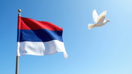 Serbian flag in wind with flying white dove and clear blue sky