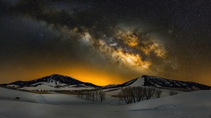 Magnificent starry night sky above snow-covered mountain range in a winter landscape