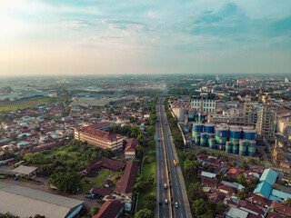 Obraz premium Aerial view of Medan Industrial Park, Indonesia, showcasing factories, highways, and urban development. Perfect for themes of industry, logistics, infrastructure, and economic growth