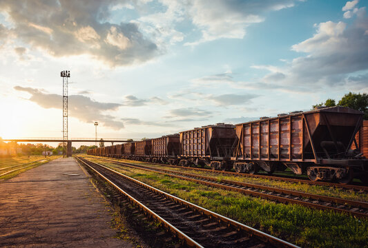 Abandoned railway station. Rusty freight train at sunset. 