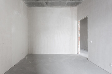 Obraz premium interior of the apartment without decoration in gray colors. rough finish