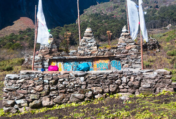 Peaceful stone structure with prayer flags and colorful decor in a scenic Himalaya.