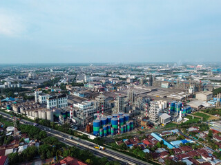 Fototapeta premium Aerial view of Medan Industrial Park, Indonesia, showcasing factories, highways, and urban development. Perfect for themes of industry, logistics, infrastructure, and economic growth