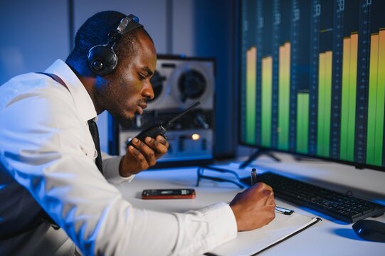 Secret agent listens on the reel tape recorder. Officer wiretapping in headphones