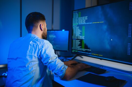 Portrait of male programmer in office at night