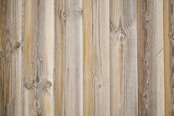 Old weathered wooden fence planks with knots and nail holes. Vertical orientation with a natural...