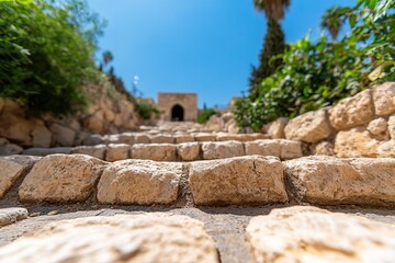Fototapeta premium Church holy sepulchre city worship. Stone pathway leading to an archway, surrounded by greenery.