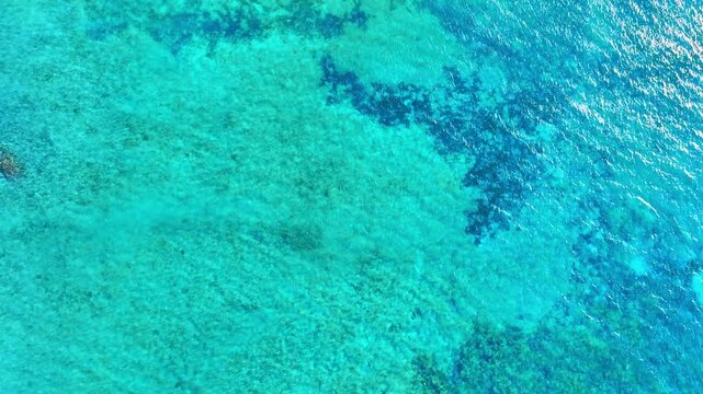 Turquoise waters of the Caribbean Sea. Tropical aerial seascape. Exotic tourism, panoramic destination, summer vacation. Natural blue waters of the tropical ocean.