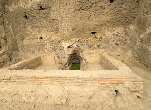Pompeii, Campania, Italy - July 6, 2024: Ancient Roman City ruins on Via Dell' Abbondanza. Terme Stabiane building, the Stabian Baths. Water in and out of the bath
