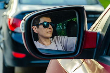 Side Mirror Reflection of woman Driver in Sunglasses