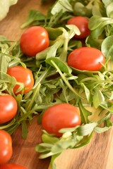 Fresh ripe cherry tomatoes and lettuce on a cutting board