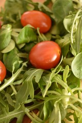 Fresh ripe cherry tomatoes and lettuce on a cutting board