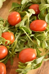 Fresh ripe cherry tomatoes and lettuce on a cutting board