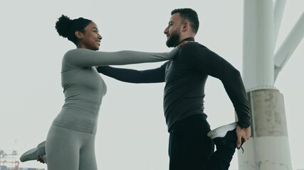 A diverse man and woman couple in activewear stretch together, fostering fitness and companionship in an outdoor setting.