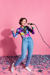 Full size vertical photo of nice young woman sing wear pullover isolated on pink color background