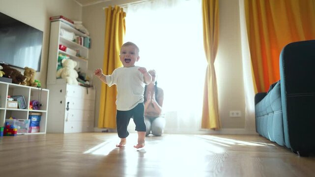 Family helps toddler learn walk. Mother supports toddler learning to walk. first steps bring family joy. Family bonding as toddler learns walk. toddler learns walk. Family celebrates walking milestone
