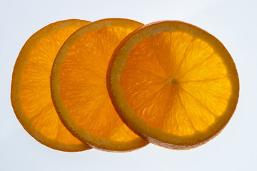 three orange GMO fruit slices on white background 