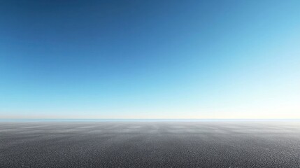 Empty asphalt road under a clear blue sky.
