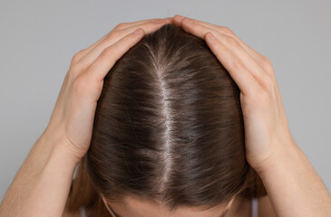 Fototapeta premium Girl with hair loss problem on grey background, closeup